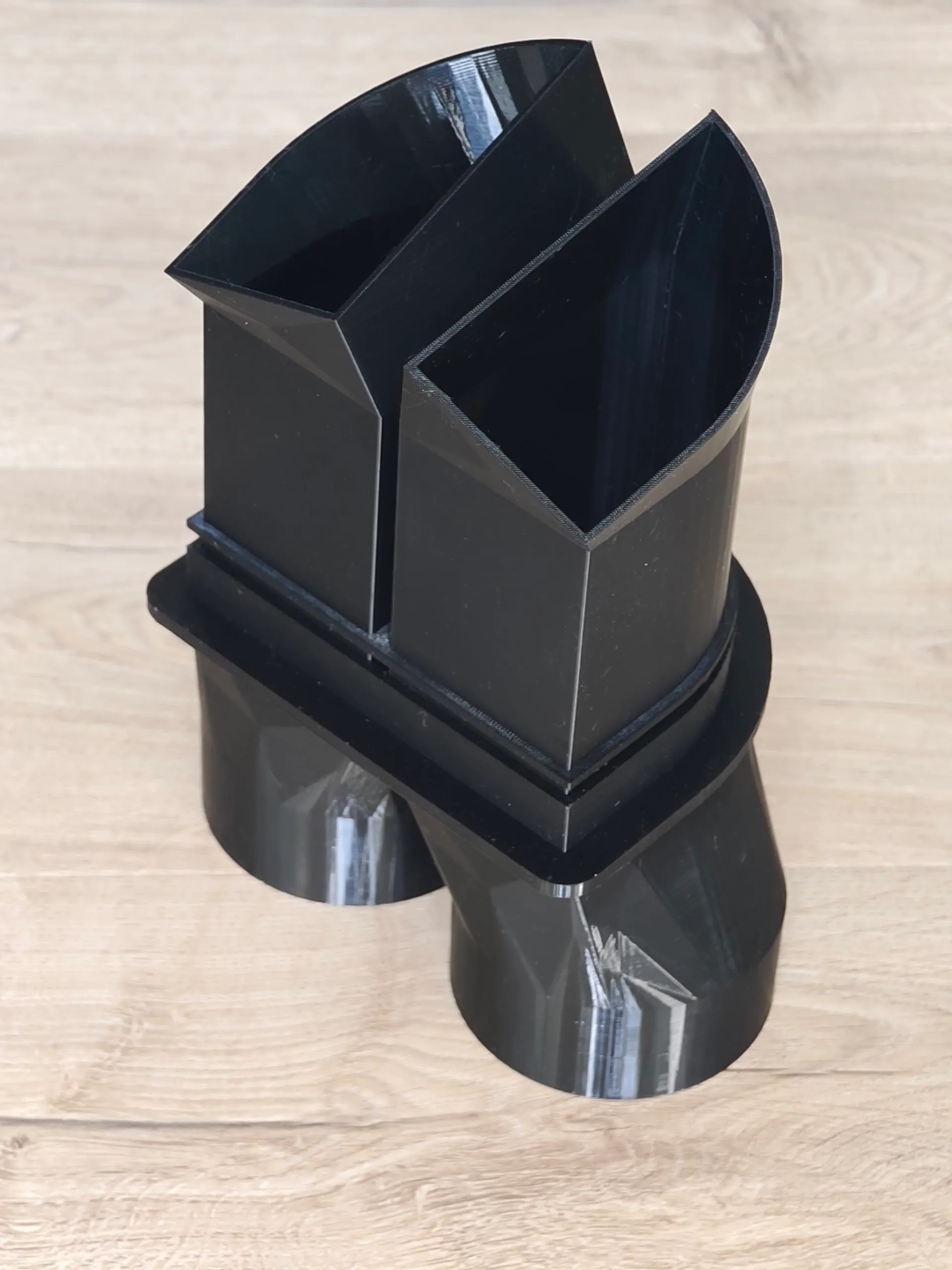 The 3D printed duct transition part resting on a workbench